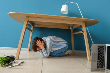 Deprem sırasında masanın altında saklanan genç kadın.