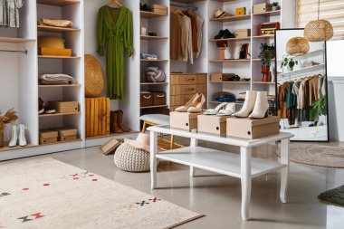 Açık butikte şık kıyafetler, ayakkabılar ve aksesuarlar.