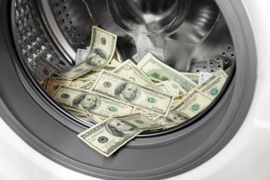 Çamaşır makinesindeki dolar banknotları, yakın plan.