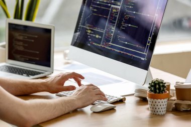 Ofiste bilgisayarla çalışan erkek programcı, yakın plan.