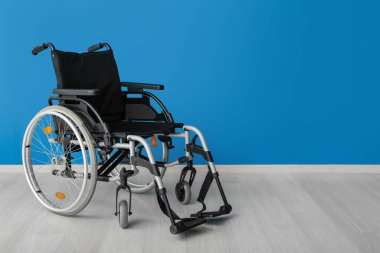 Mavi duvarın yanında modern boş tekerlekli sandalye