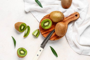 Tahta tahta tahta, taze kivi ve beyaz arka planda yapraklar.