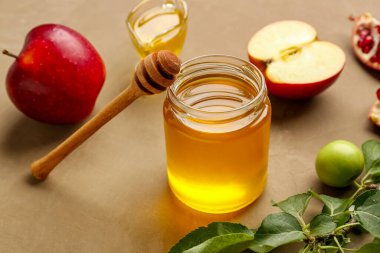 Rosh Hashanah kutlaması (Yahudi Yeni Yılı) için kahverengi arka planda bal ve elma kavanozu.