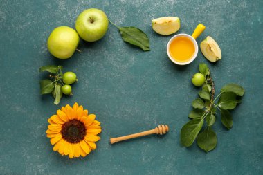 Mavi arka planda Rosh Hashanah kutlaması (Yahudi Yeni Yılı) için ballı, elmalı ve ayçiçekli çerçeve