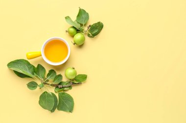 Rosh Hashanah kutlaması için sarı arka planda bir kase bal ve elma.