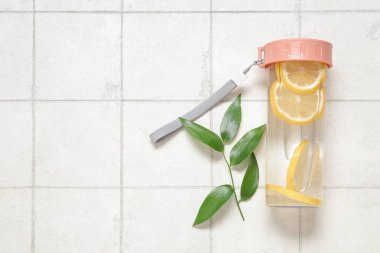 Limonlu spor şişesi ve beyaz fayanslı yapraklar.