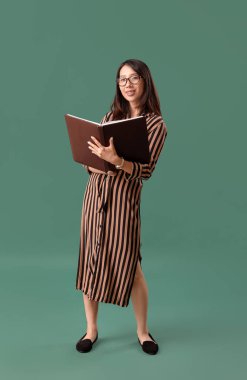 Yeşil arka planda sınıf kaydı olan Asyalı kadın öğretmen