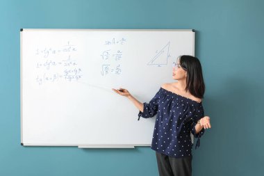 Sınıfta yazı tahtasının yanında Asya Matematik öğretmeni