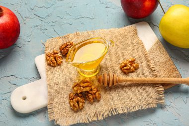 Sosu bol bol bal, ceviz, nar ve elmalar mavi arka planda.