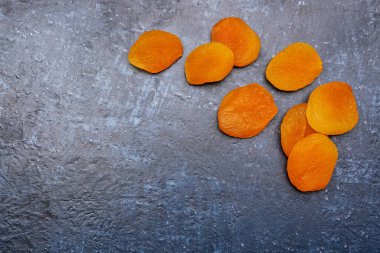 Mavi arka planda lezzetli kurutulmuş kayısılar.