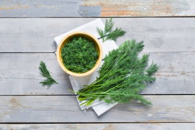 Gri ahşap arka planda taze dereotlu kase