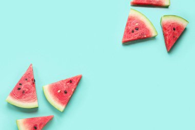 Turkuaz zemin üzerinde olgun karpuz parçaları olan kompozisyon