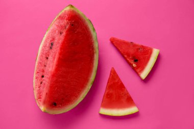 Pembe zemin üzerinde olgun karpuz parçaları olan kompozisyon