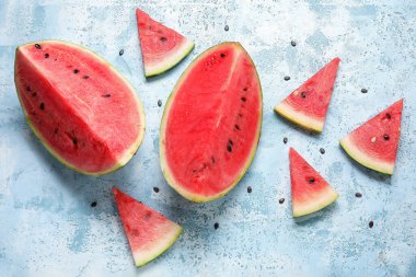 Açık mavi zemin üzerinde olgun karpuz parçaları olan kompozisyon