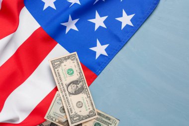 ABD bayrağı ve mavi arka planda dolar banknotları