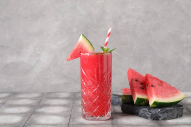 Bir bardak lezzetli karpuz suyu ve gri fayanslı nane.