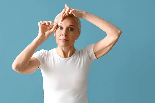 Mature Woman Doing Face Building Exercise Blue Background — Stock Photo, Image