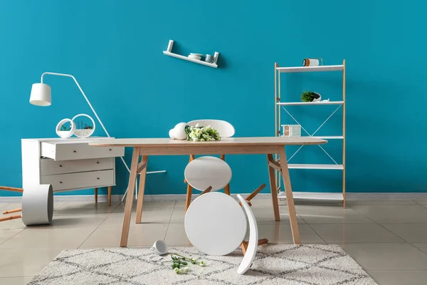 stock image Dining table with fallen vase and flowers in messy room