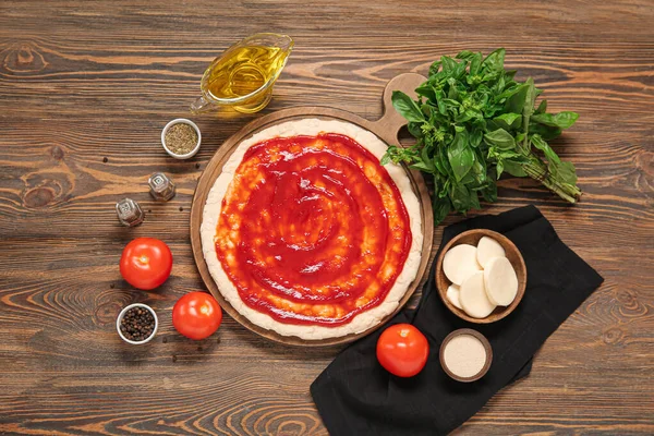 Pizzateig Mit Tomatensauce Und Zutaten Auf Holzgrund — Stockfoto