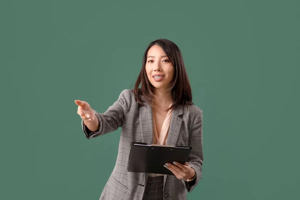 Kvinnelig Asiatisk Lærer Med Utklippstavle Grønn Bakgrunn – stockfoto