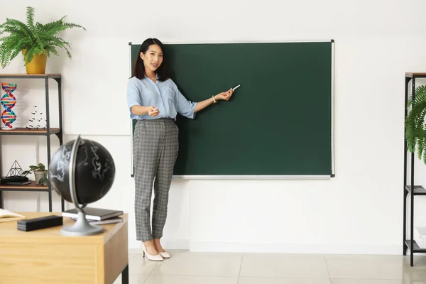 教室のチョークボード近くの女性アジアの教師 — ストック写真