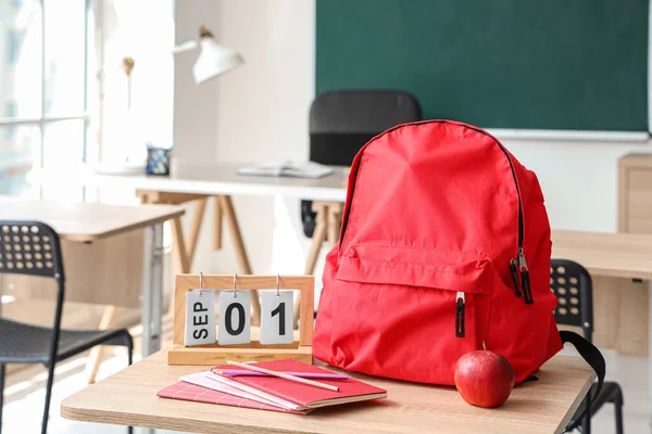 Piros Iskolás Hátizsák Írószerrel Naptárral Friss Almával Asztalon Osztályteremben — Stock Fotó