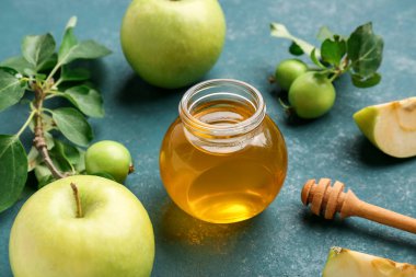Rosh Hashanah kutlaması için kavanoz bal ve elma (Yahudi Yeni Yılı) mavi arka planda