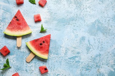 Lezzetli karpuz çubukları ve açık mavi arkaplanda nane şekerli kompozisyon