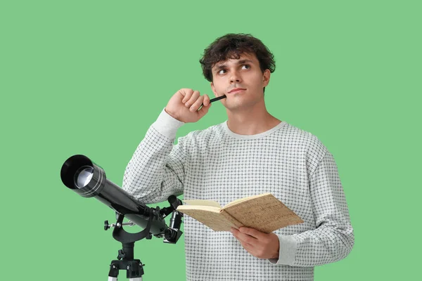 Tänksam Ung Man Med Teleskop Och Anteckningsbok Grön Bakgrund — Stockfoto