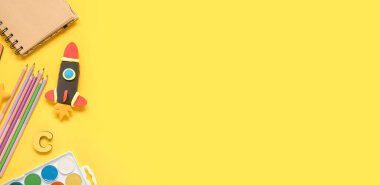 Roket, sarı zemin üzerinde plastikten ve kırtasiyeden yapılmış ve metin için alanı var.