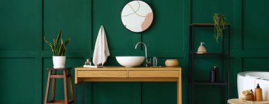 Lavabosu, masası, aynası ve raf ünitesi olan şık bir banyo.