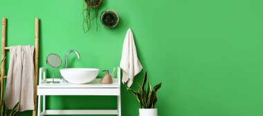 Beyaz masası, lavabosu ve çiçekleri olan şık bir tuvalet. Tasarım için pankart