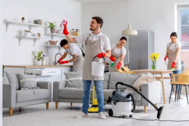 Young janitors cleaning in kitchen