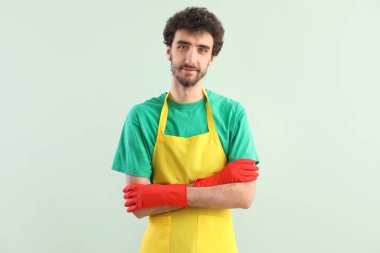 Yeşil arka planda lastik eldivenli genç adam.