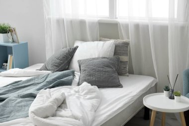 Yumuşak yastıklı rahat bir yatak ve çocuk odasında buruşuk battaniyeler.