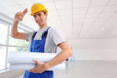 Odasında duvar kağıtları olan bir erkek müteahhit.