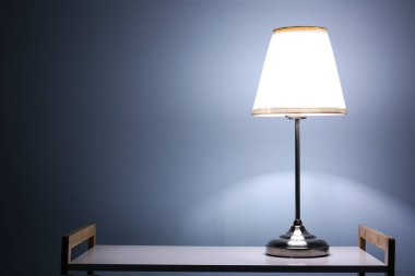 Karanlık odadaki raflarda parlayan lamba.