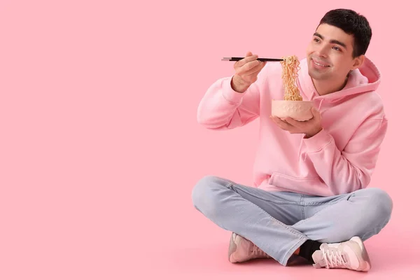 Młody Człowiek Miską Chińskiego Makaronu Siedzi Różowym Tle — Zdjęcie stockowe