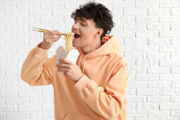 Young Man Eating Tasty Chinese Food White Brick Background — Stock Photo, Image
