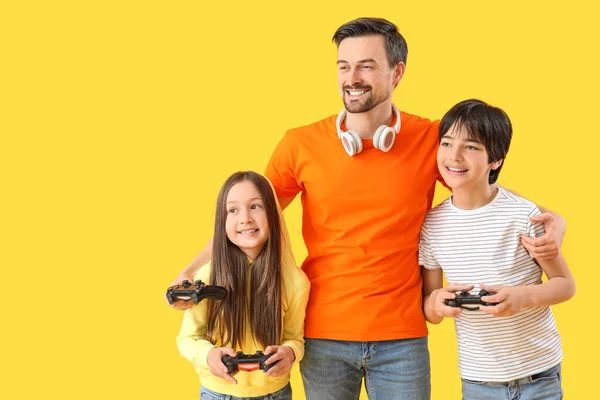 Vater Mit Seinen Kleinen Kindern Beim Videospiel Auf Gelbem Hintergrund — Stockfoto