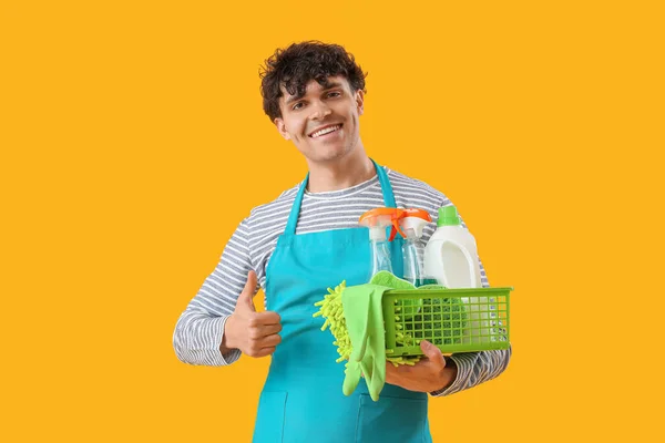 Young Man Basket Cleaning Supplies Showing Thumb Yellow Background — Stock Photo, Image