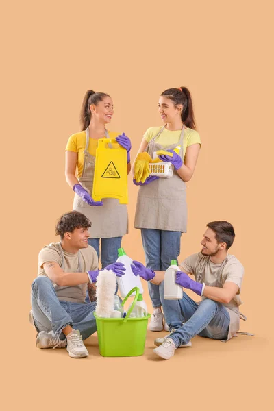 Jovens Zeladores Com Suprimentos Limpeza Fundo Bege — Fotografia de Stock