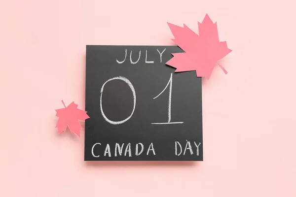 stock image Chalkboard with text 1ST JULY CANADA DAY and maple leaves on pink background