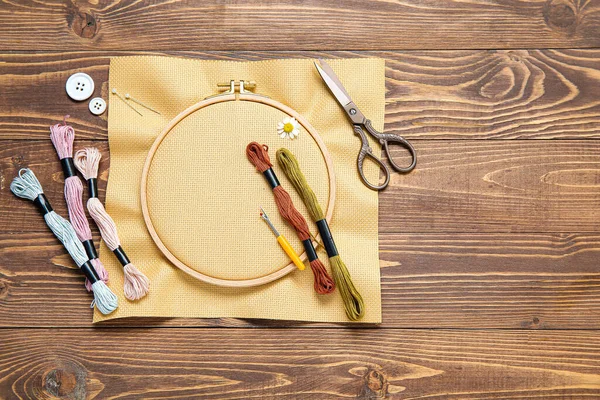 用帆布 剪子和毛线线在褐色木制背景上做绣花圈 — 图库照片