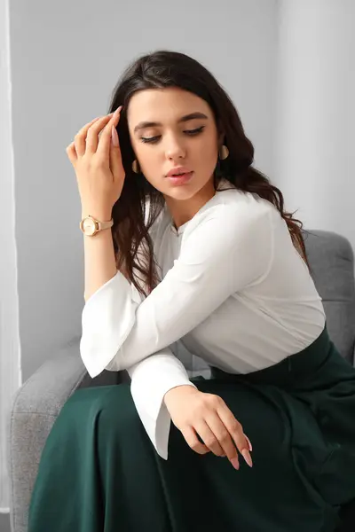 Schöne Junge Frau Mit Armbanduhr Sitzt Auf Sessel Zimmer — Stockfoto