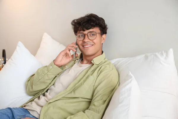 Ung Man Med Glasögon Talar Med Mobiltelefon Sovrummet — Stockfoto