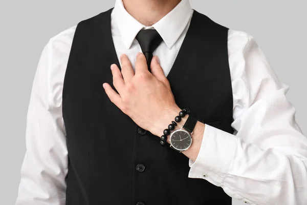Стильний Молодий Бізнесмен Наручним Годинником Регулює Краватку Сірому Фоні Крупним — стокове фото