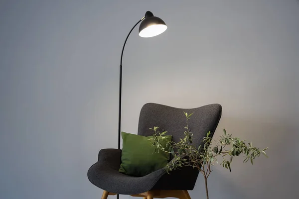 Leuchtende Lampe Grauer Sessel Mit Kissen Und Zimmerpflanze Grauer Wand — Stockfoto