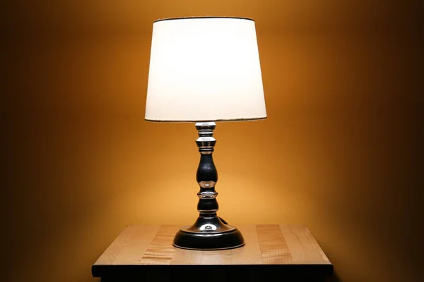黑暗房间里木制桌子上闪亮的灯 — 图库照片