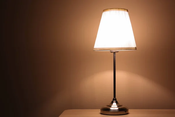 Karanlık Odadaki Ahşap Masada Parlayan Lamba — Stok fotoğraf